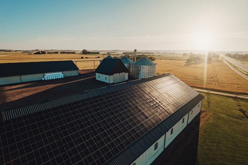 Solarthermie nutzt die Kraft der Sonne, um Wasser zu erwärmen oder Räume zu beheizen. Auf dem Bild sieht man ein großes Haus dem Land mit einer Solaranlage auf dem Dach.