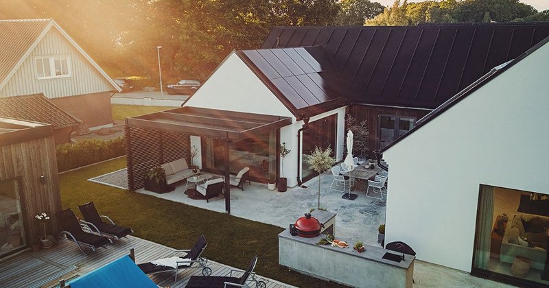 Ett hus med solceller på taket och poolhus